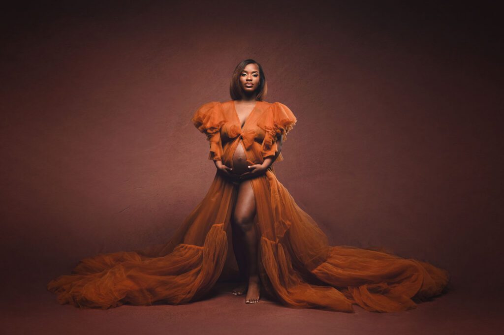 Dramatic studio maternity portrait in Huntsville Alabama with flowing orange gown